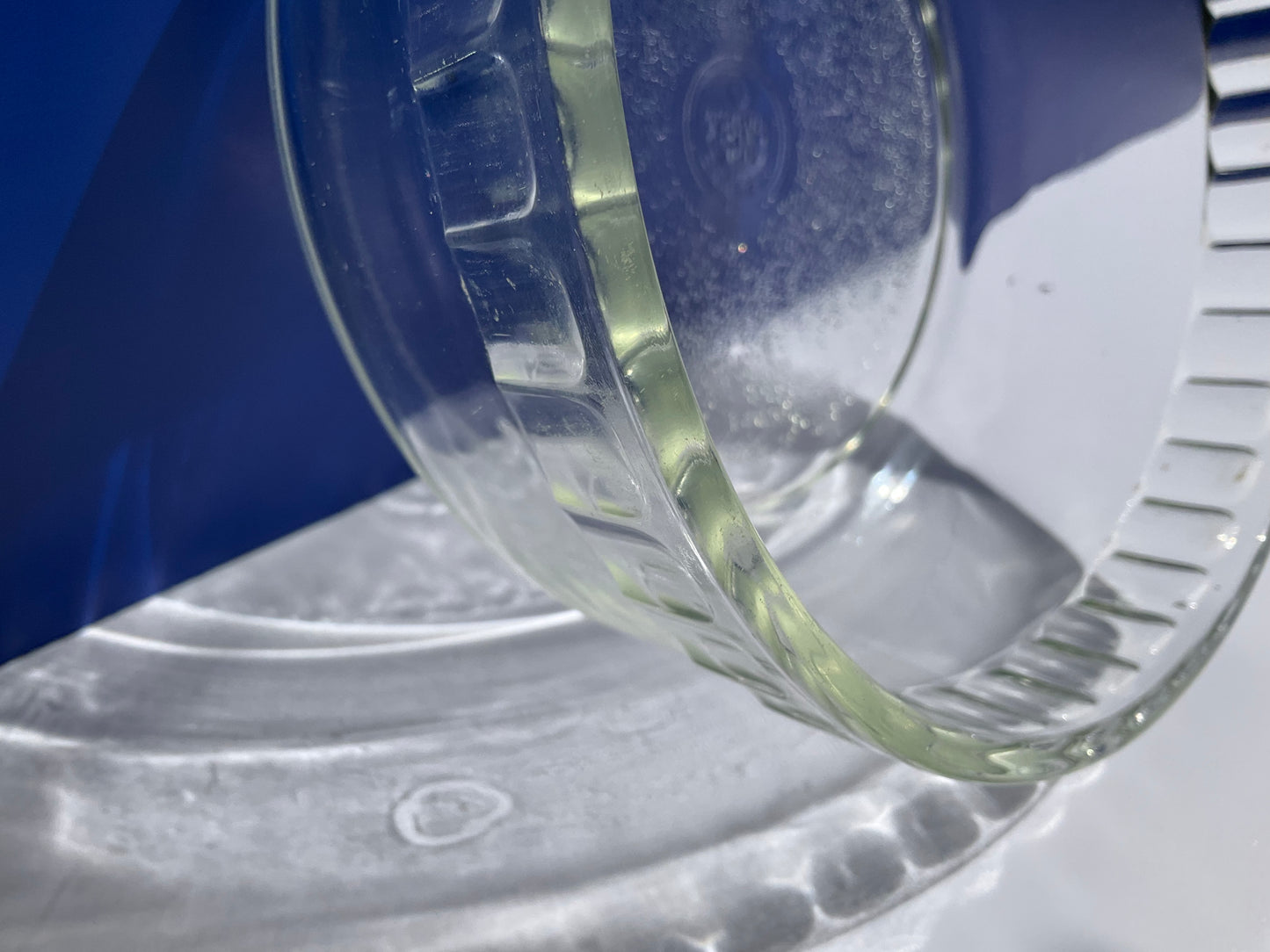 Close up view of rim of Pyrex clear tempered glass souffle dish on a white background