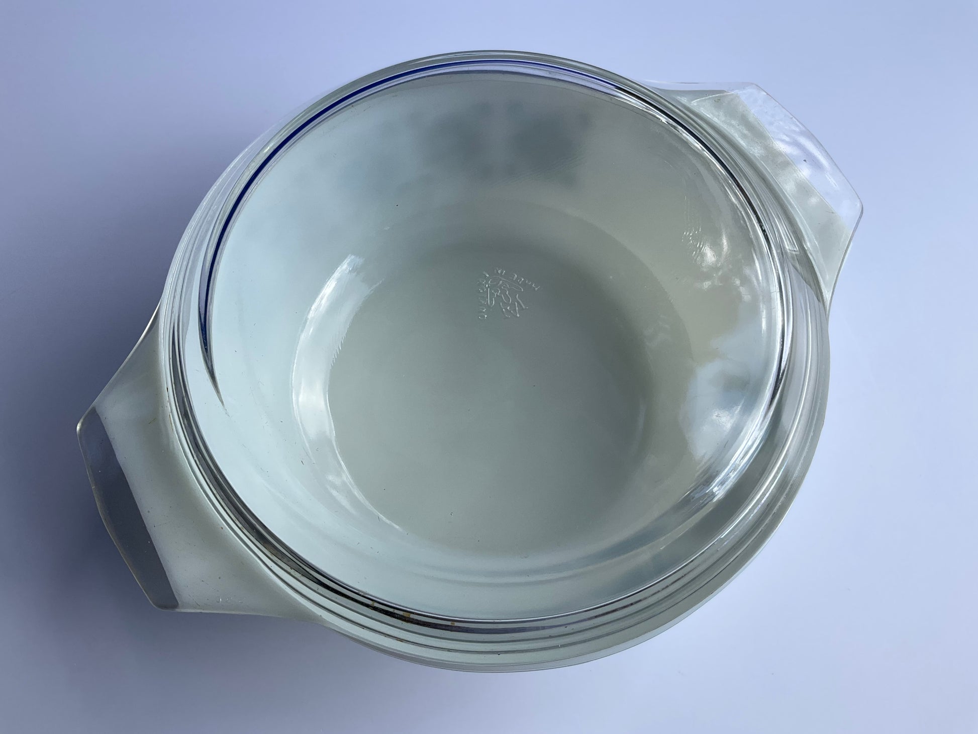 Top view of Pyrex JAJ tempered milk glass oven casserole with  a clear glass lid on a white background 