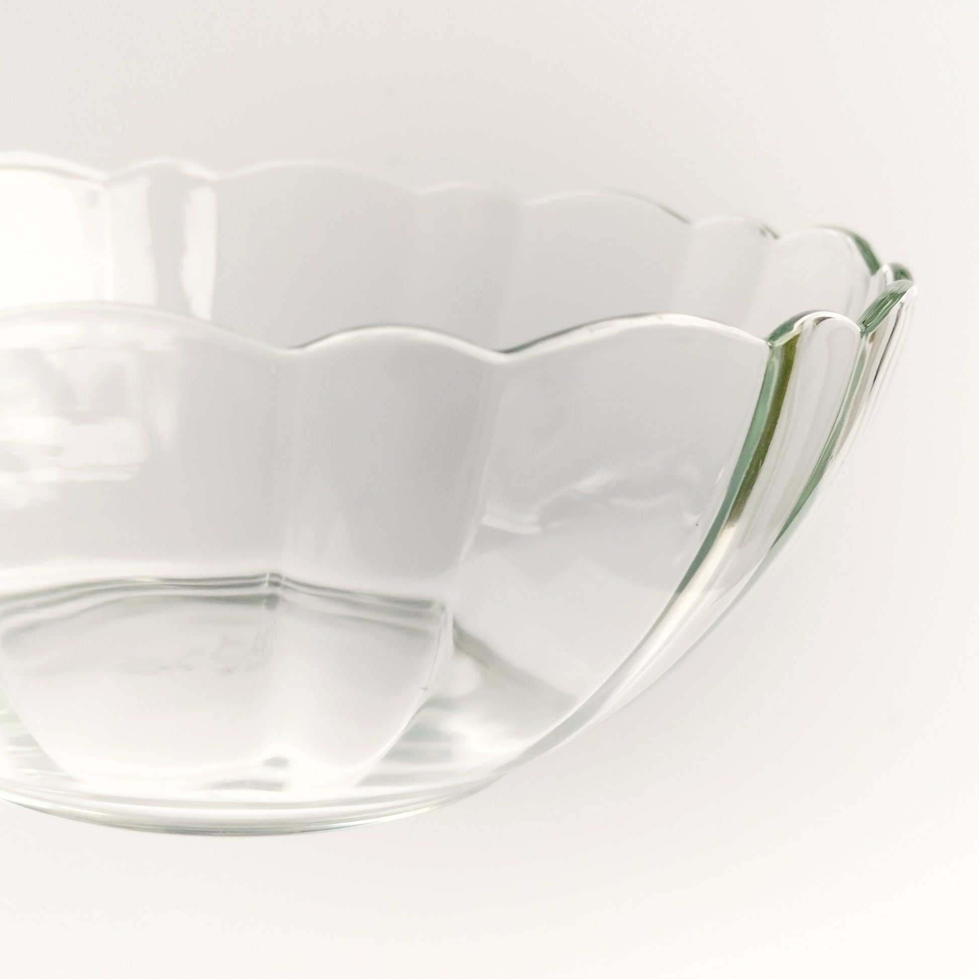 Close up of scalloped clear tempered glass bowl by Arcoroc on white background