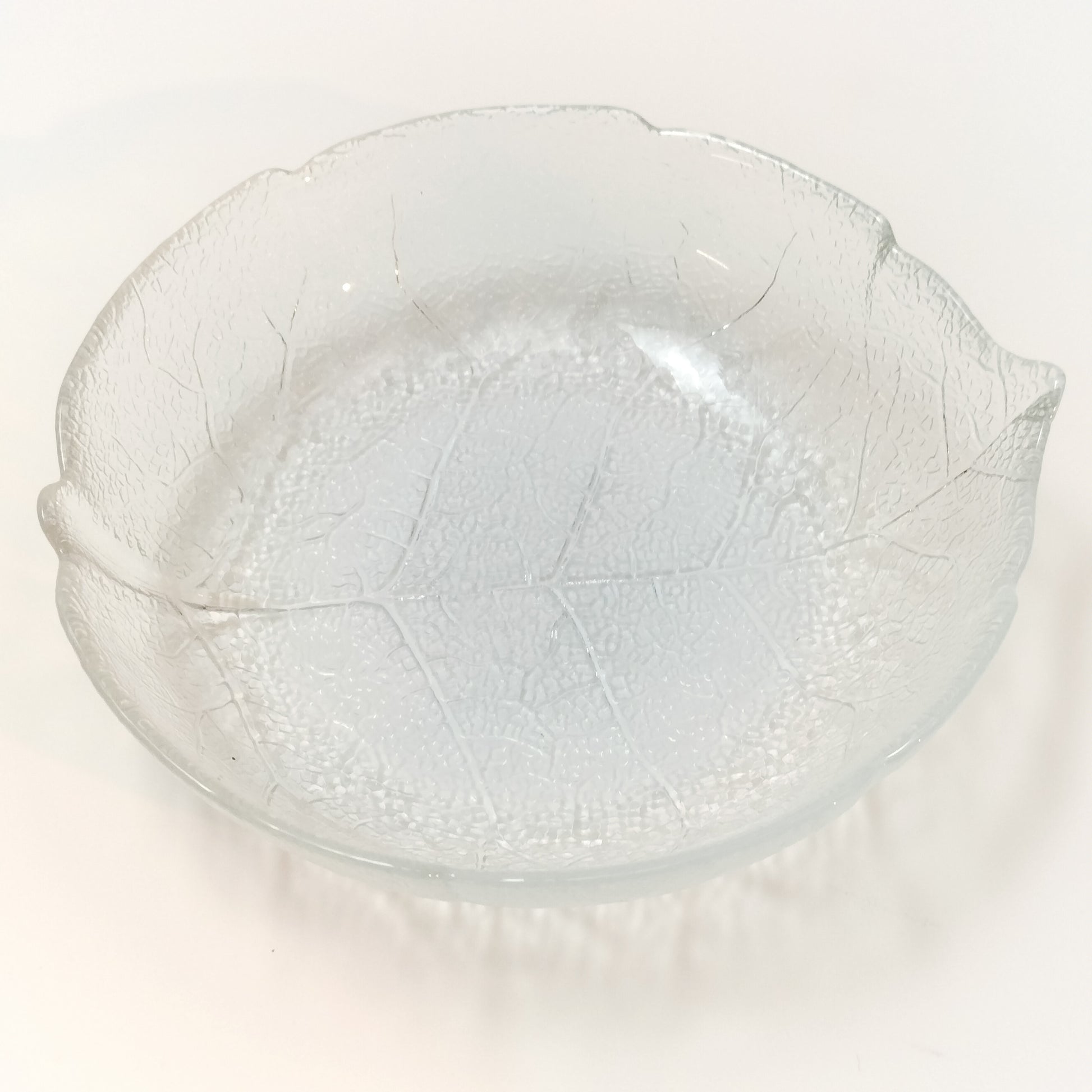 Top view of Arcoroc Aspen clear tempered glass pasta plate with leaf pattern on white background