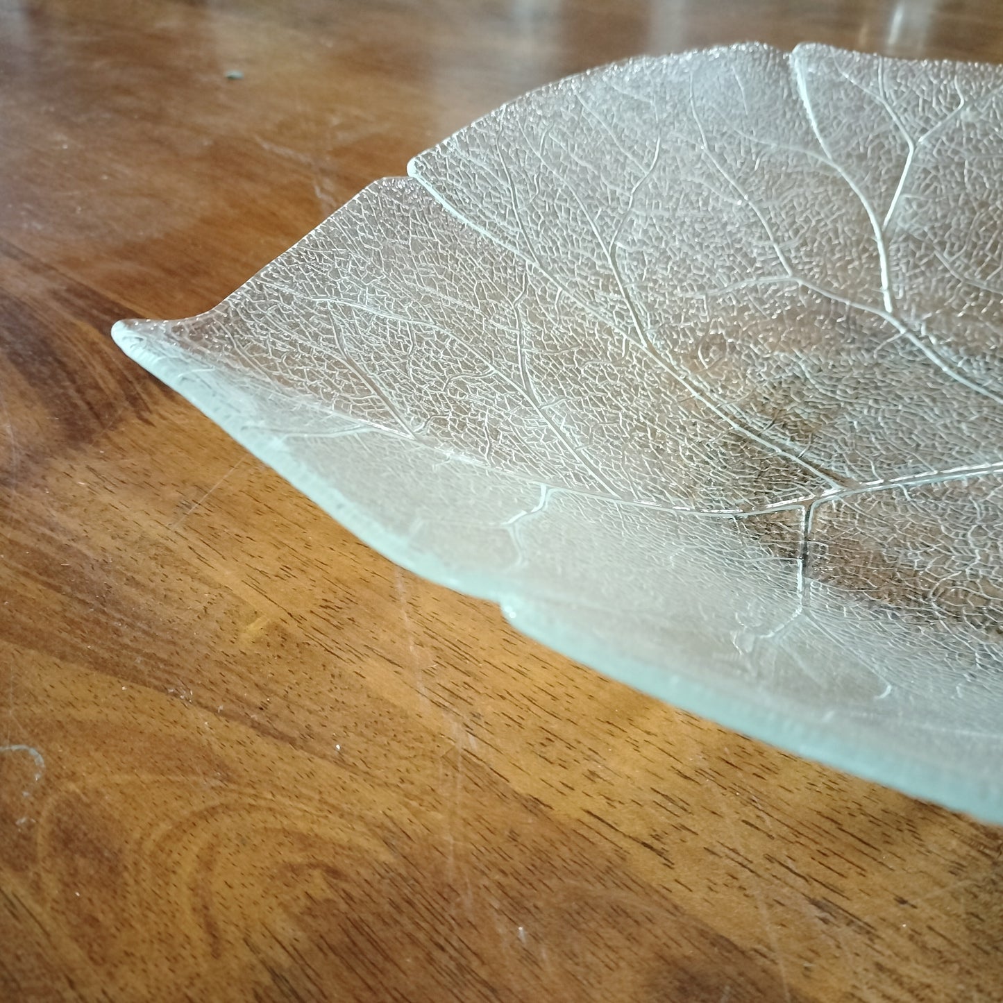 Close up of Arcoroc Aspen clear tempered glass serving plate with leaf pattern on wood background